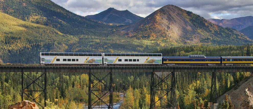 A luxury passenger train traveling through the majestic Canadian Rocky Mountains